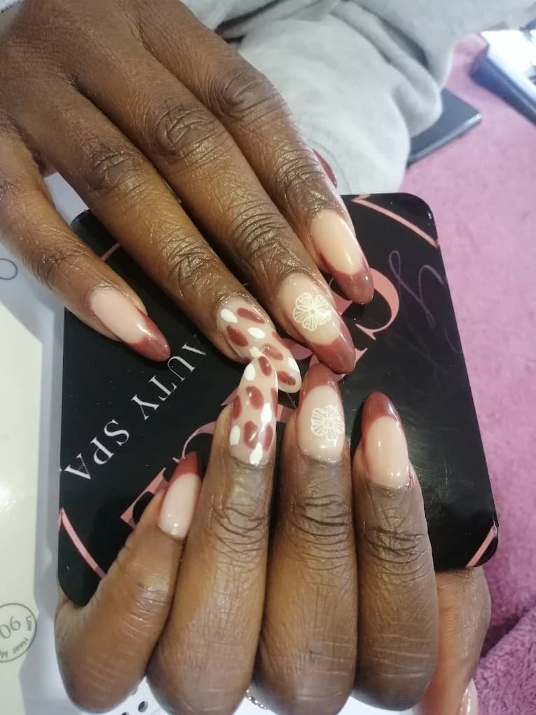 Brown french tips with white polka dots on the accent nails.
