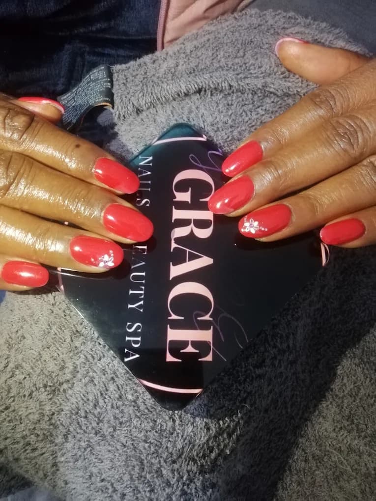 Deep red nails with hand-painted floral detail.